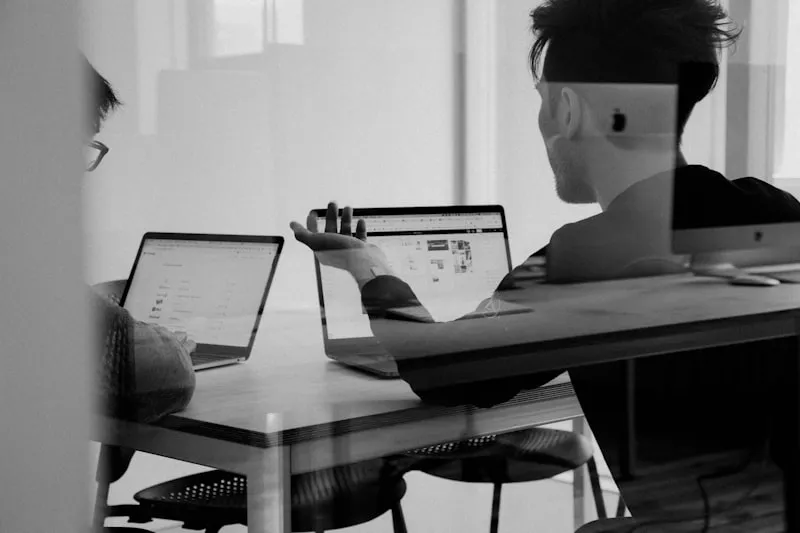 Team arbeitet gemeinsam an Laptops in einem Büro